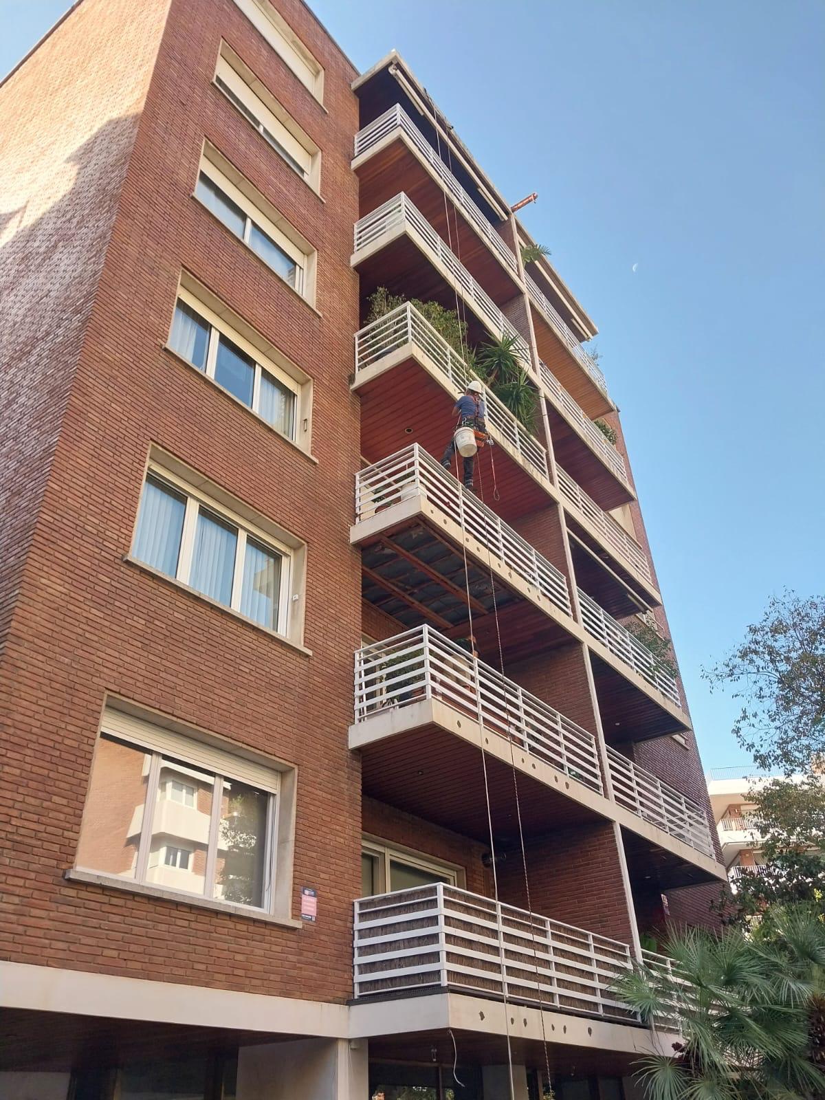 Edificio de ladrillo con cuerdas de acceso colgando por las terrazas
